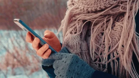Close-up side view of woman's hands typing on mobile phone blurred background Stock Footage 123073141