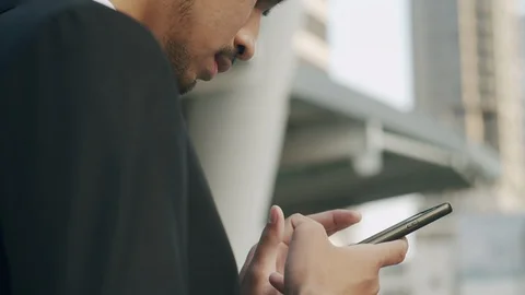 Close up. Side view of young businessman while standing using smart phone Stock Footage 120812705