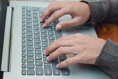 Close up side view young man typing with laptop on table in livingroom, remote Foto stock