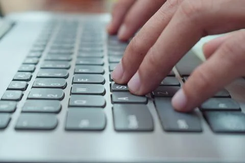 Close up side view young man typing with laptop on table in livingroom, remote Stock Photos