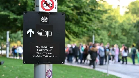 Close up of a sign for the Queen's Lying in State with a large queue of peopl Stock Footage 210831065