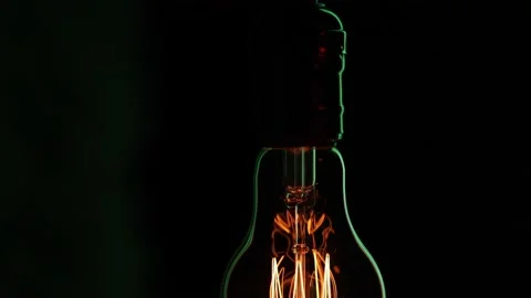 Close up silhouette of a glowing light bulb in the dark. Stock Footage 146945899