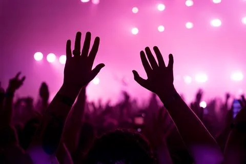 Close up of silhouette of hands in the crowd at a summer music concert or Stock Photos