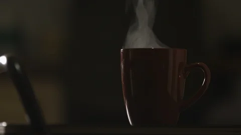 Close up silhouette of red cup on the table. Girl takes a cup with a hot drink.  Video stock 126677372