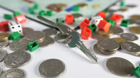 Close up of silver and gold coins and  dice with house door keys thrown Stock Footage 89192324