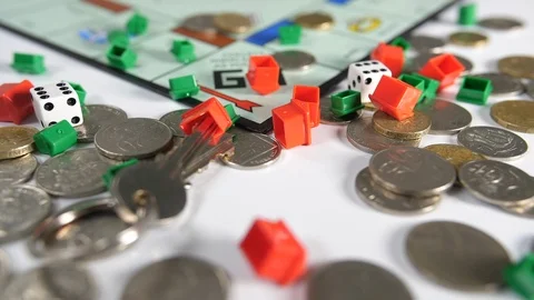 Close up of silver and gold coins and double dice with house door keys thrown Stock Footage 89192622