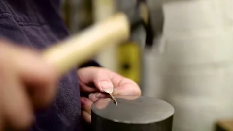 Close up of silver being hammered Stockbeeldmateriaal 84899682