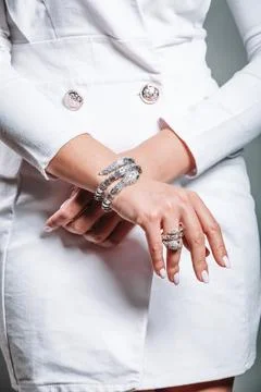 Close-up of a silver bracelet and a ring on the hand of a woman in a white ja Stock Photos