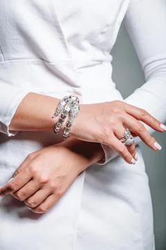 Close-up of a silver bracelet and a ring on the hand of a woman in a white ja Foto stock