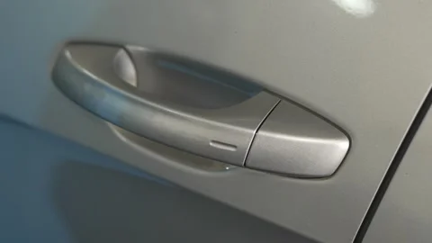 Close-up of a silver car door handle with keyless entry sensor slot. Vidéo 342261027