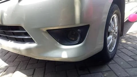 Close-up of silver car front with headlight and tire Stock Photos