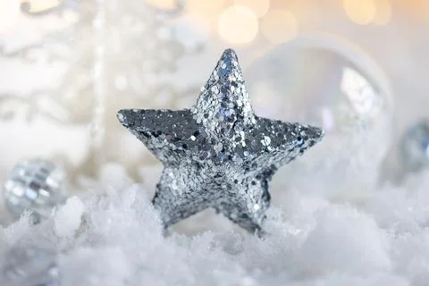 Close up silver Christmas star in artificial snow with ornaments and soft b.. 스톡 사진