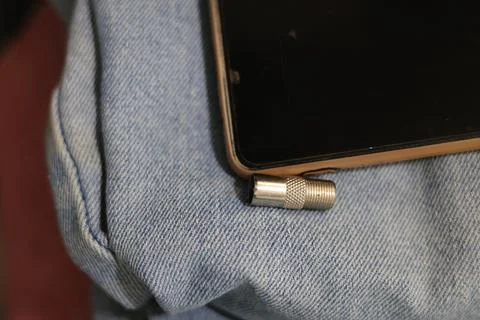 Close-up of a silver coaxial cable connector lying on a textured surface Stock Photos
