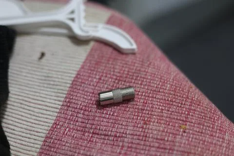 Close-up of a silver coaxial cable connector lying on a textured surface Stock Photos