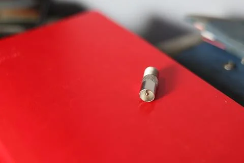 Close-up of a silver coaxial cable connector lying on a textured surface Stock Photos