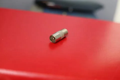 Close-up of a silver coaxial cable connector lying on a textured surface Stock Photos