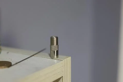 Close-up of a silver coaxial cable connector lying on a textured surface Stock Photos