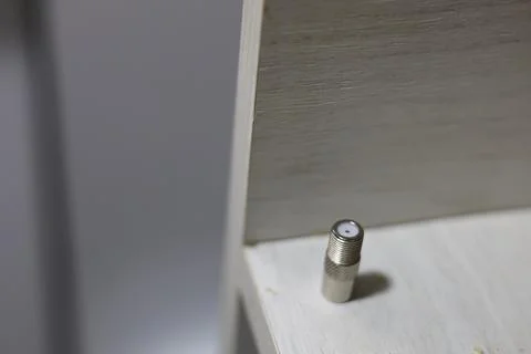 Close-up of a silver coaxial cable connector lying on a textured surface Stock Photos