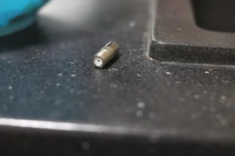 Close-up of a silver coaxial cable connector lying on a textured surface Stock Photos