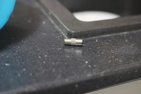 Close-up of a silver coaxial cable connector lying on a textured surface Stock Photos