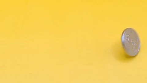 Close-up of a silver coin on a yellow background Stock-Footage 333925875