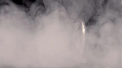 Close up silver Ethereum coin spinning through smoke against black Stock Footage 217949309