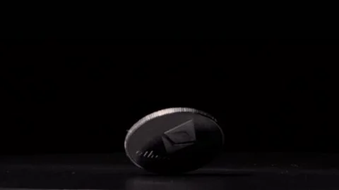 Close up silver Ethereum coin spinning at an angle slowly  against black Stock Footage 217949363