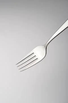 Close up of a silver fork on grey gradient background Stock Photos