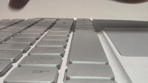 Close-up of silver keyboard keys. Finger presses a key on keyboard. Key dep.. Stock Footage 345398953