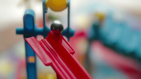 Close-up of a silver marble ball falling out of a plastic bucket Vídeos de archivo 328125805