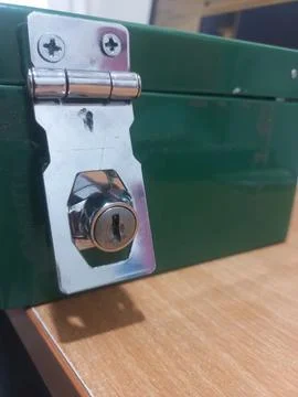 Close up of silver metal latch lock on a green metal storage box. Stock Photos