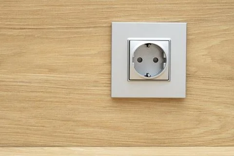 Close-up of silver plastic socket on the wooden wall above a desk Stock Photos