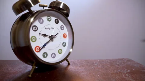 Close-Up of a Silver Retro Alarm Clock on a Wooden Table Stock Footage 337384972