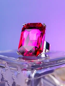 Close-up of a silver ring with a large pink stone  against a purple backgroun Stock Photos
