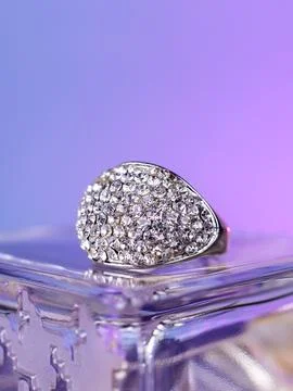 Close-up of a silver ring with white rhinestones    against a purple  backgro Stock-Fotos
