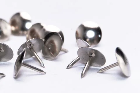 Close-up of Silver Thumb Tacks on White Background, Shiny Metal Pins, Offic.. Stock Photos