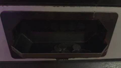 Close-up of silver token coins falling from a black arcade game  Stock Footage 304975426