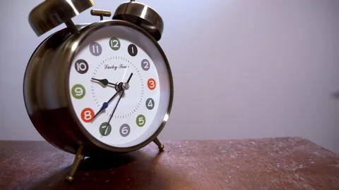 Close-Up of Silver Twin-Bell Clock on Wood with Slow Black Second Hand Stock Footage 337384245