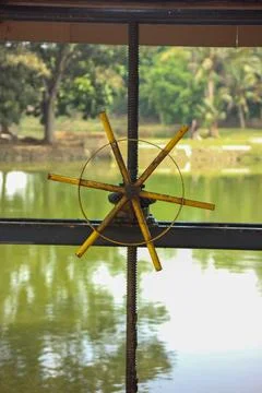 Close up of a simple, handmade wind spinner, in a window frame. It's a blur.. Stock Photos