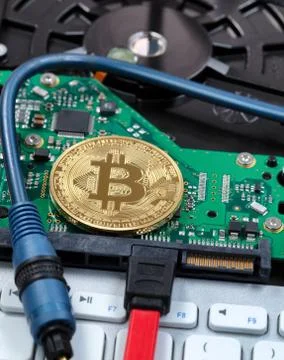 Close up of a single bitcoin on circuit board of computer with fiber optic ca Stock Photos