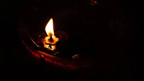 Close-up of a single lit candle in darkness with a warm orange glow Stock Footage 345722541