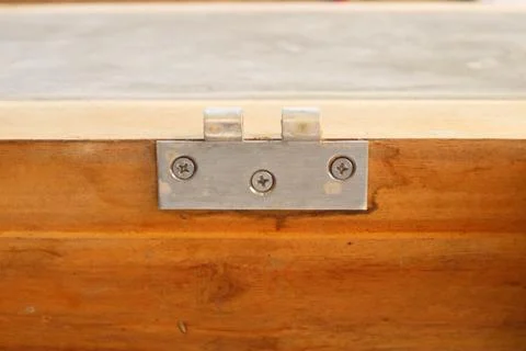 Close-up of a single metal hinge securely fastened with three Phillips scre.. Stock Photos