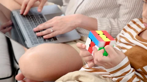 Close up of single mom using laptop for work from home and looking son sitt.. Stock Footage 249451837