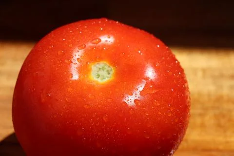 Close up of single red tomato on kitchen board Stock Photos