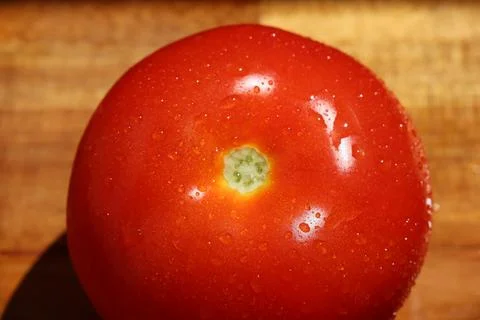 Close up of single red tomato on kitchen board Stock Photos