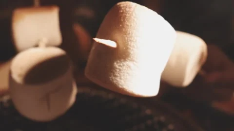 Close up of single toasted marshmallow skewered on wooden stick melting ove.. Stock Footage 343613689