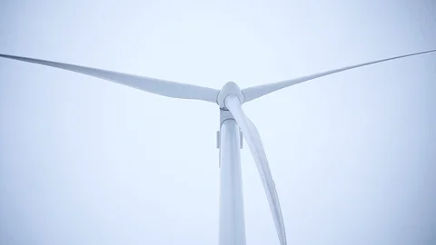 Close up single wind turbine spins around generating energy in winter field man Stock Footage 105204840
