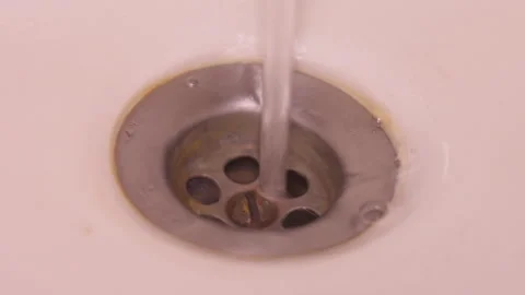 Close-up of Sink Drain Strainer with Water Flowing Through Holes 스톡 동영상 335235510