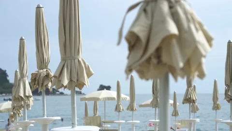 Close-up of the sinking between folded beige beach umbrellas on a sunny summer Stock Footage 196509442