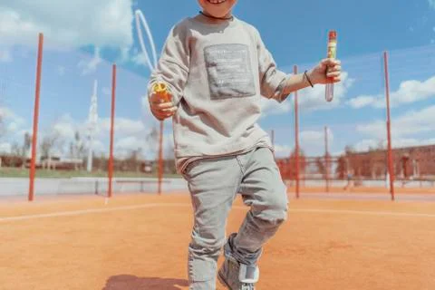 Close up of skateboading and making bubbles boy at colourful playground. Stock Photos